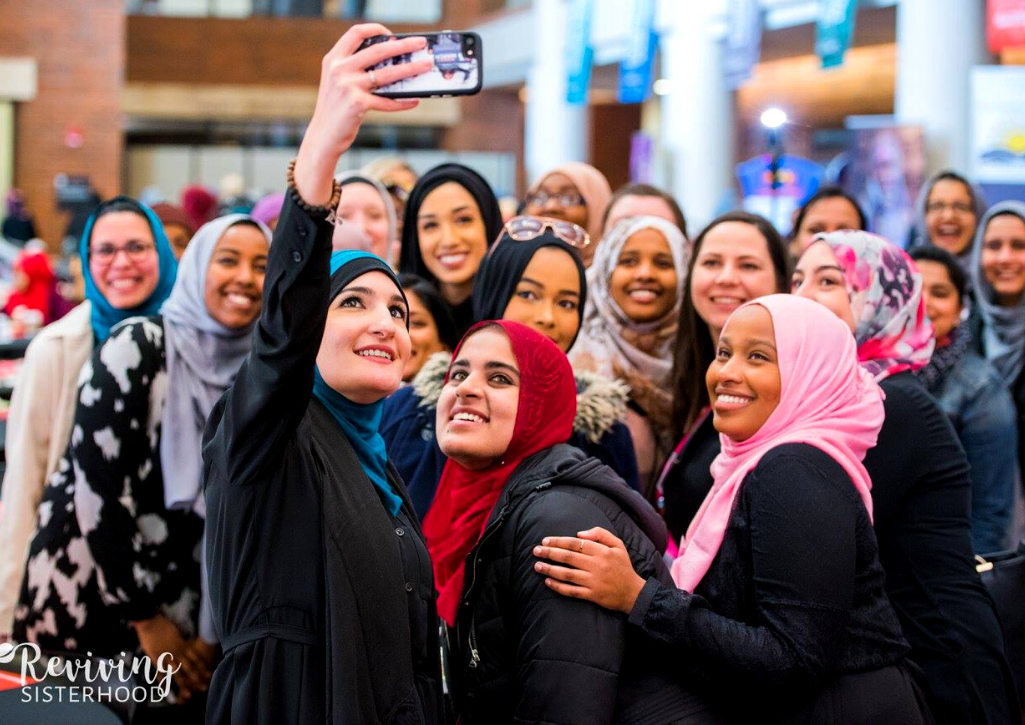 A group of women wearing hijab taking a selfie at a giving circle event