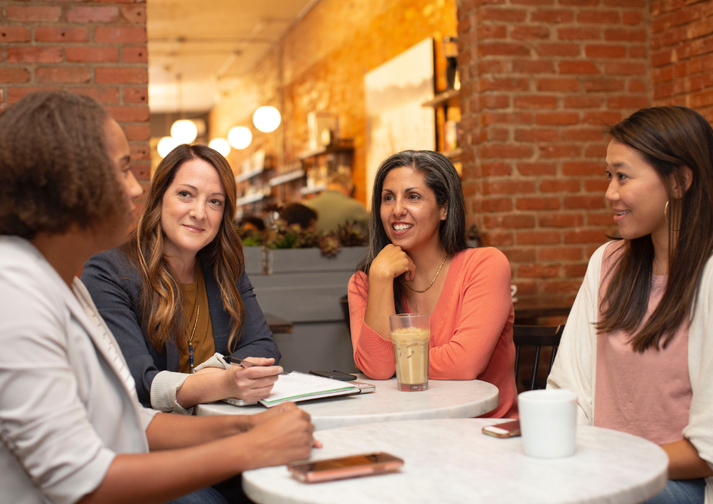 4 women sitting around a table discussing their giving circle