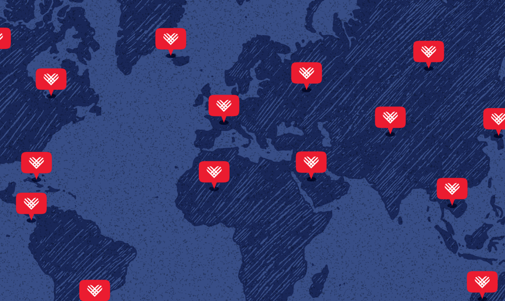 A Blue map of most of the world with 15 red speech bubbles with white GivingTuesday Hearts in them.
