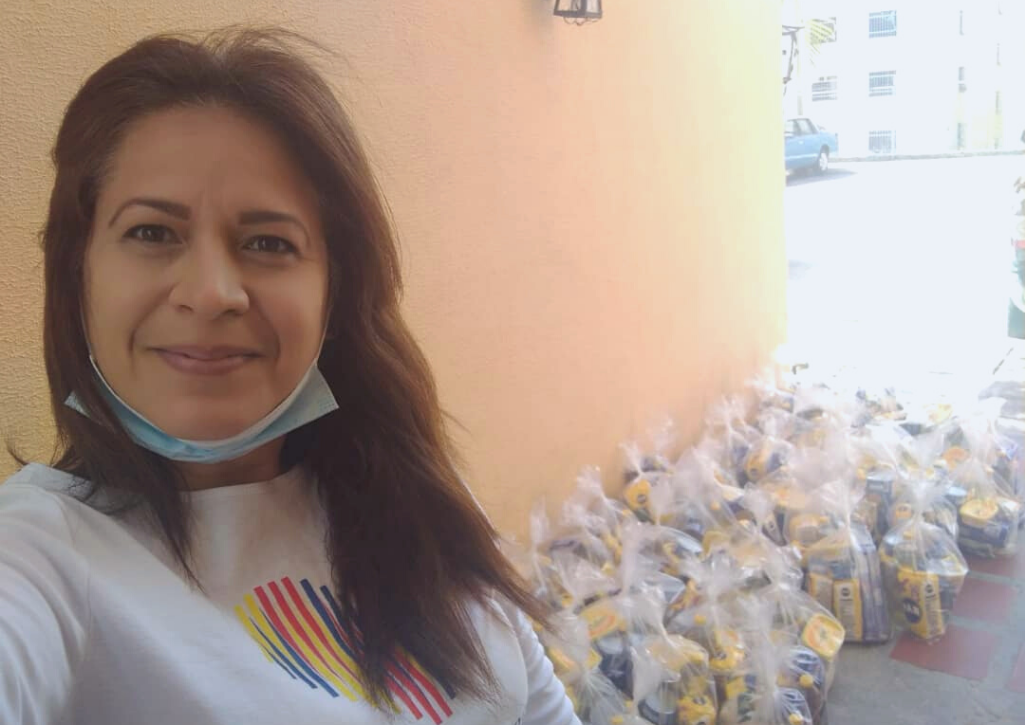 A Venezuelan woman standing proudly in front of goods she collected for her community