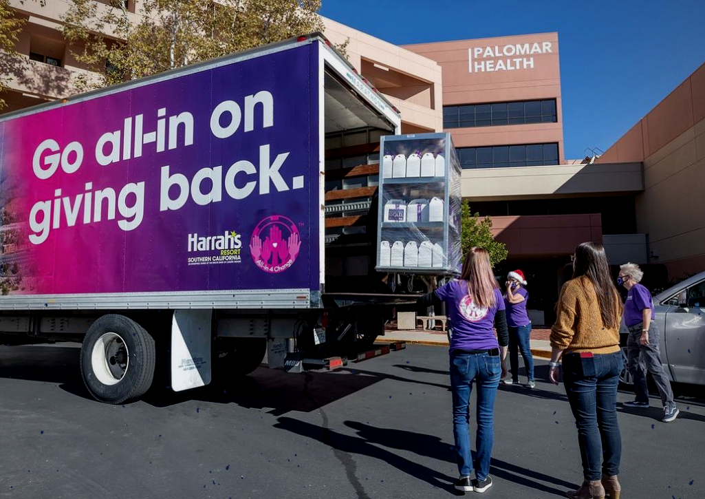 People loading goods into a truck that says 