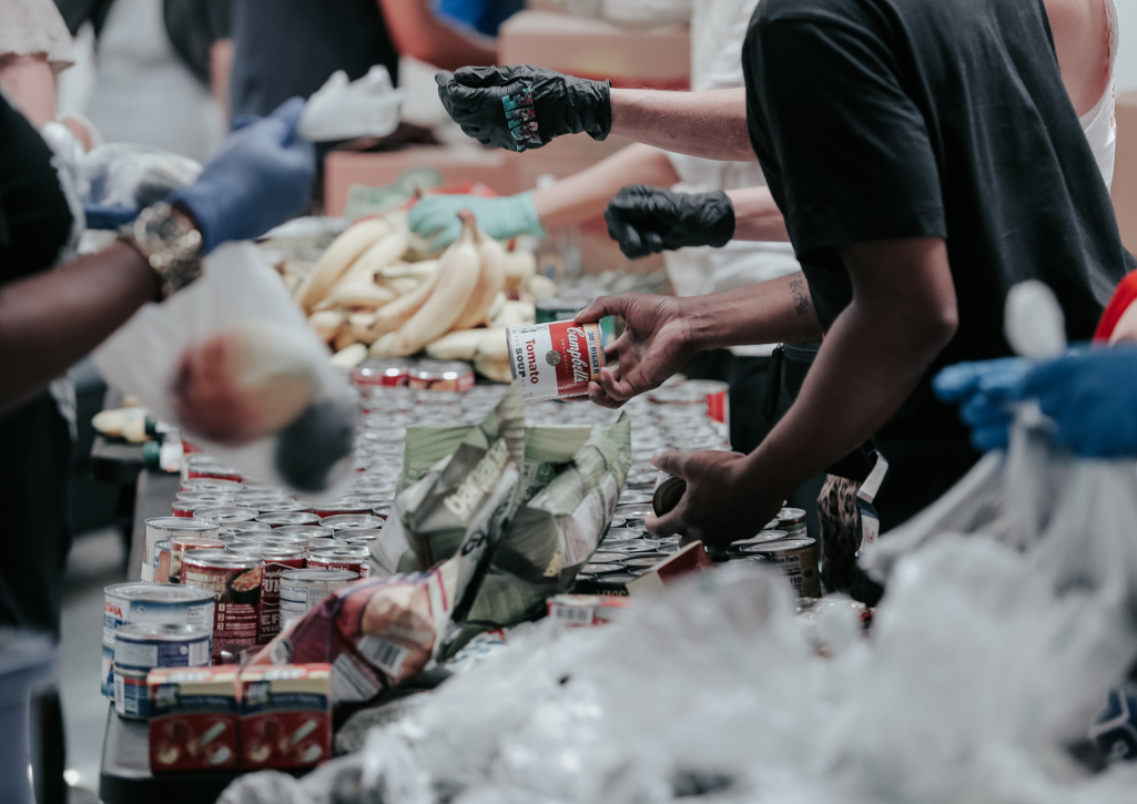 A close up shot of people wearing gloves, volunteering at the food pantry