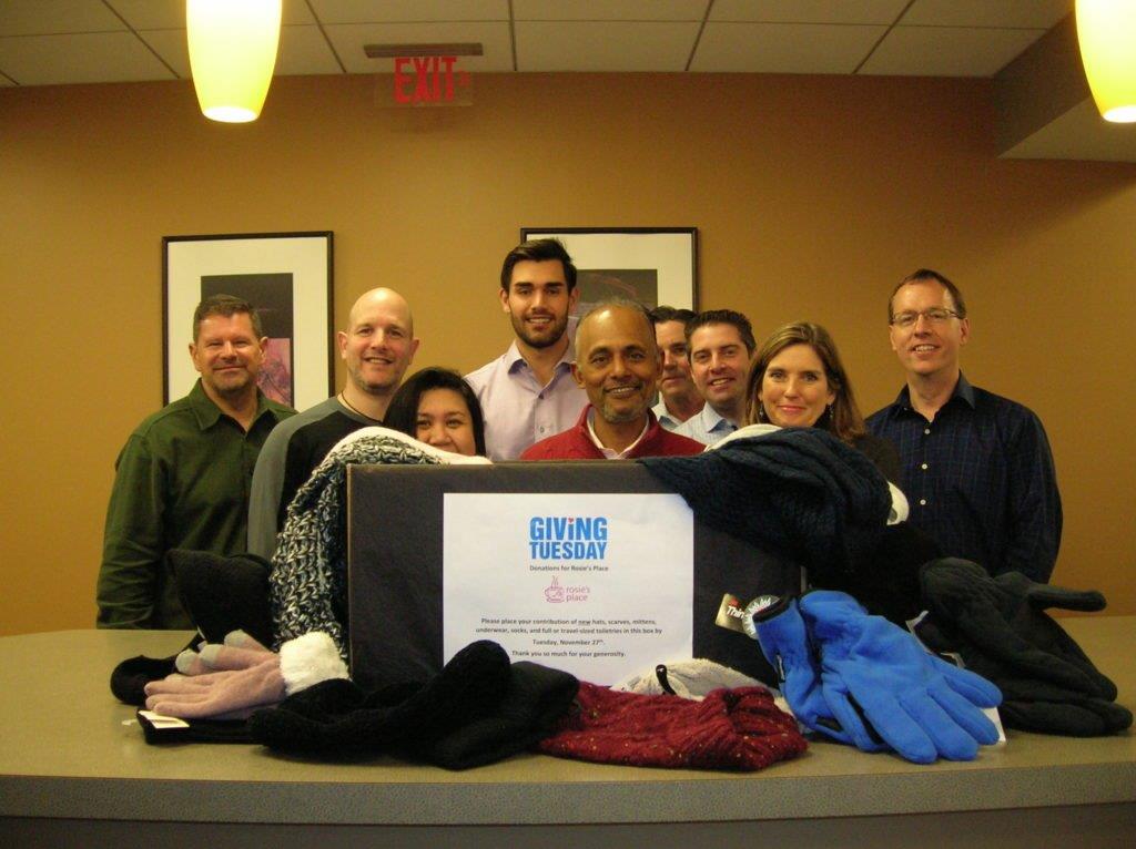 A group of people standing behind a Giving Tuesday certificate.