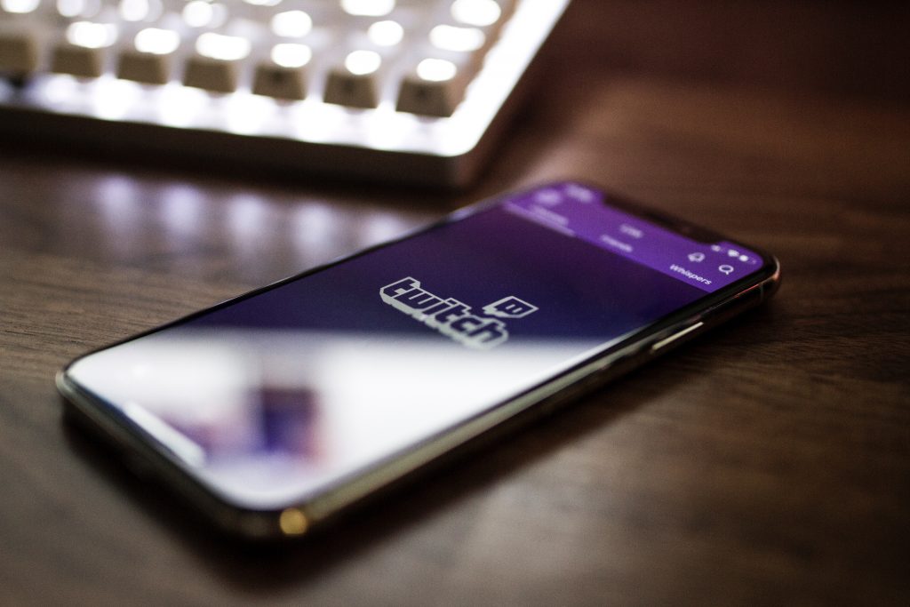 A phone with twitch open on a dark brown table.