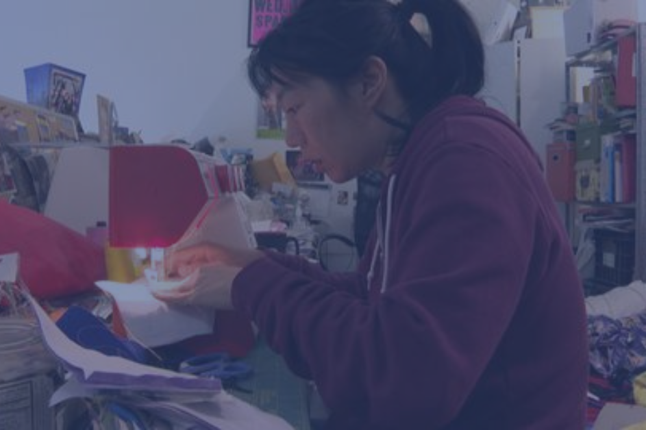 An Asian woman sewing a mask on her sewing machine as part of Aunties Sewing Squad