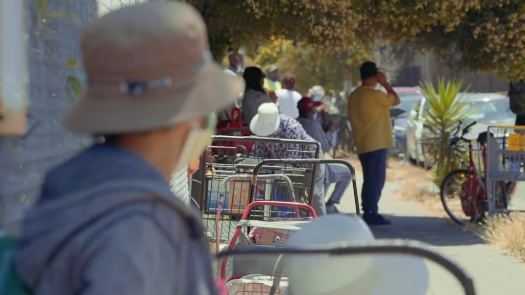 A person looks on as folks line up at the food bank