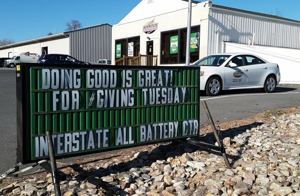 A sign outside a tire shop in West Virginia. It says "Doing good is great! GivingTuesday"