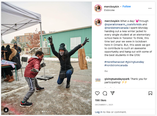 An Instagram post. The picture is of two people with their arms in the air in joy - they're standing in front of a pop up tent where they are distributing warm coats. The text reads: "What a day! 💓Through @operationwarm_coatsforkids and @nordstromcanada I spent Monday handing out a new winter jacket to every single student at an elementary school here in Toronto! To think, this time last year we were in lockdown here in Ontario. But, this week we got to contribute to such an awesome opportunity and hang out with some of the best students in the GTA!"