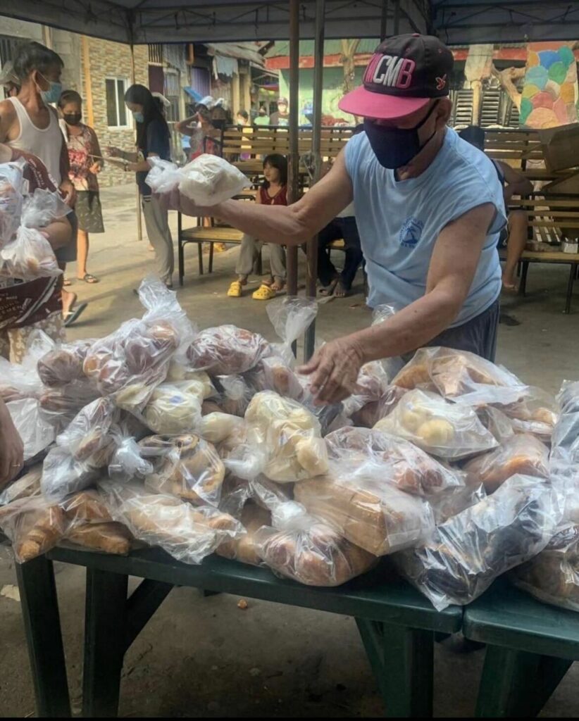 A man handing out bread
