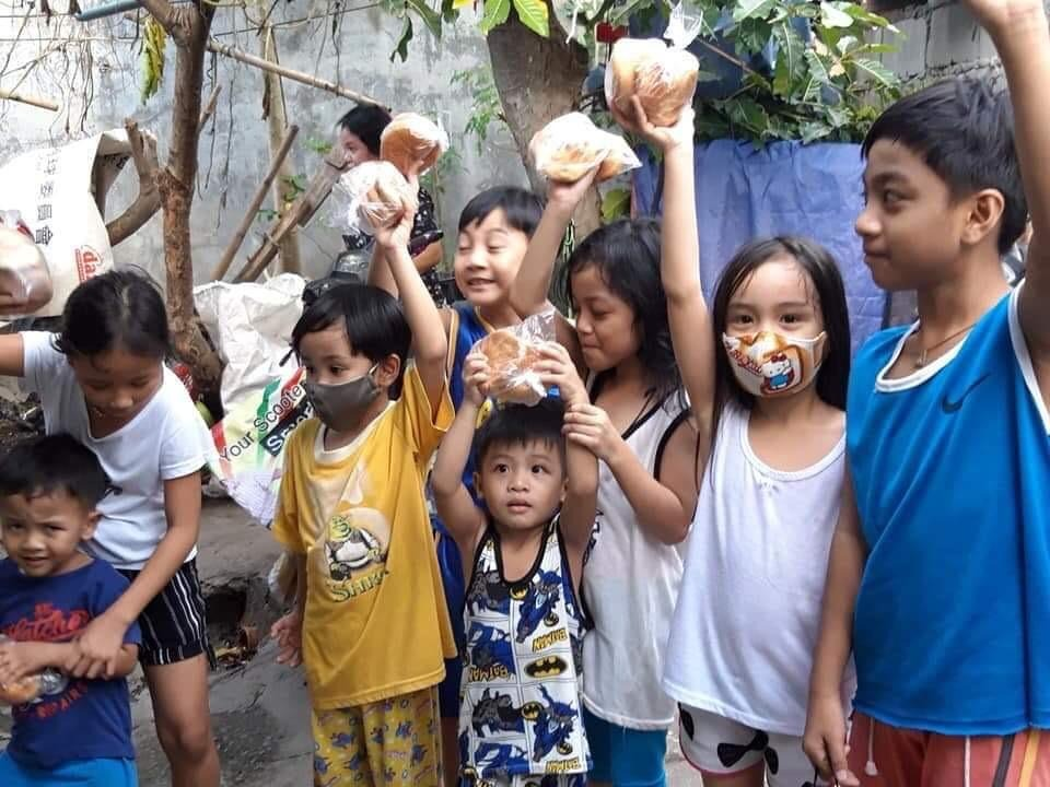 Filipino kids holding up bread