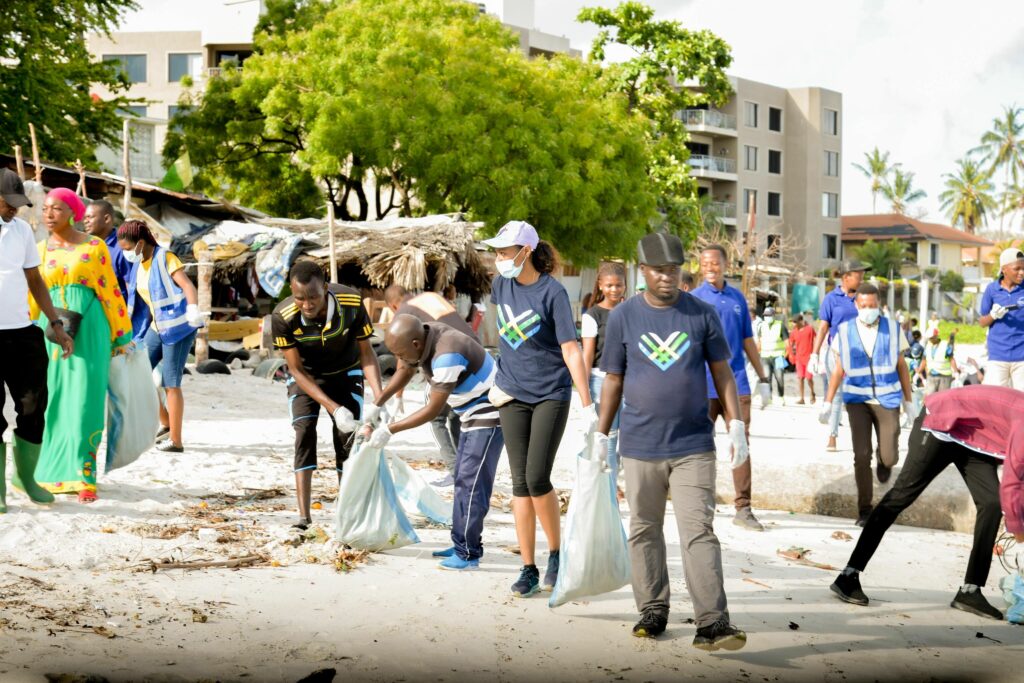 GT tanzania team wearing GivingTuesday logo shirts cleaning up their beach