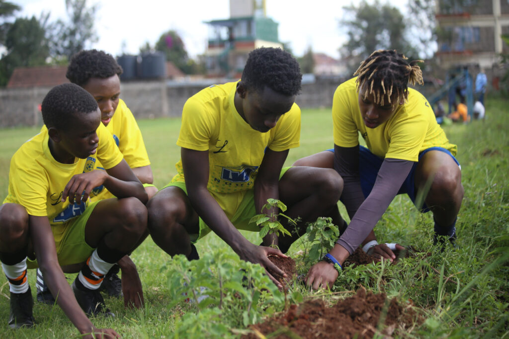 Lesein and friends planting a tree as part of Trees for Goals