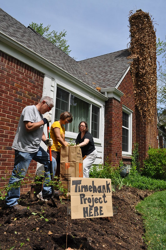 People doing landscape work with a sign that says "this is a timebank project"